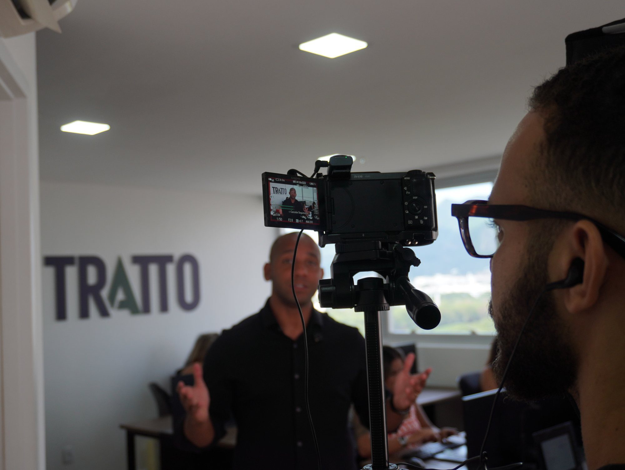 Câmera gravando no escritório da Tratto, com o logo ao fundo